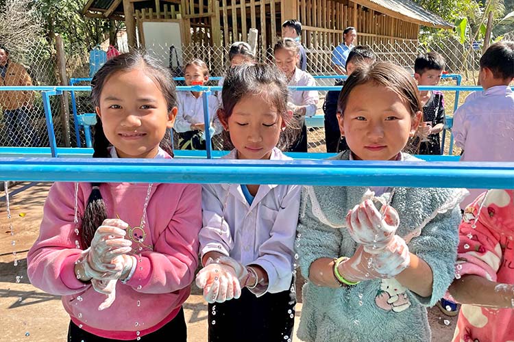 写真：建設した手洗い場で正しい手洗いを練習する子どもたち