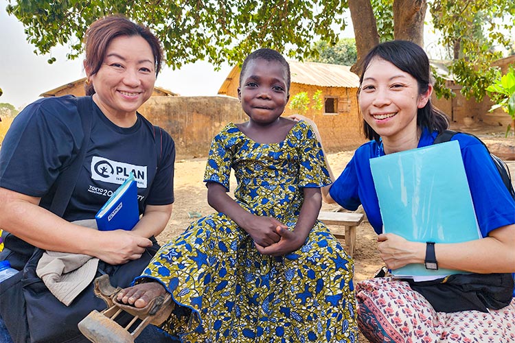 写真:プロジェクトで支援した補助器具で歩けるようになった女の子と日本のプラン職員(トーゴ)