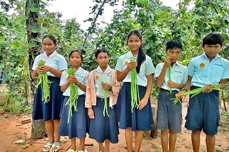 写真：収穫したインゲンを手に誇らしげな生徒たち