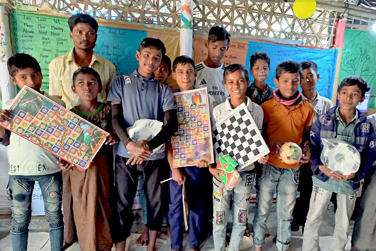 写真：課外活動用のスポーツ用具やレクリエーションアイテムを受け取った男の子たち