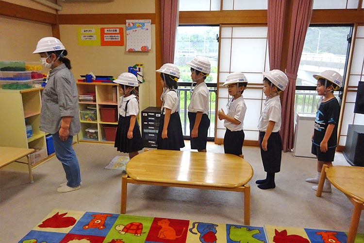 写真：配布したヘルメットを被って防災訓練