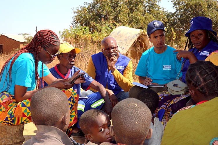写真：地域の人々から聞き取りをするプラン職員（ザンビア）