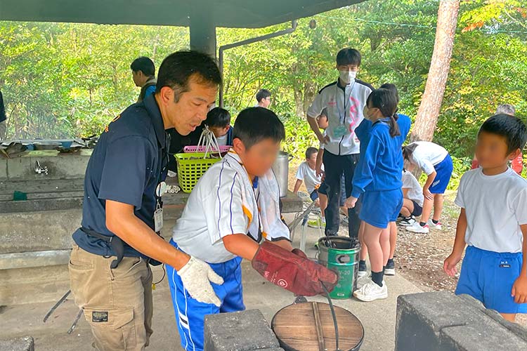 写真：慣れない手つきで炊飯に挑戦（小学校遠足）