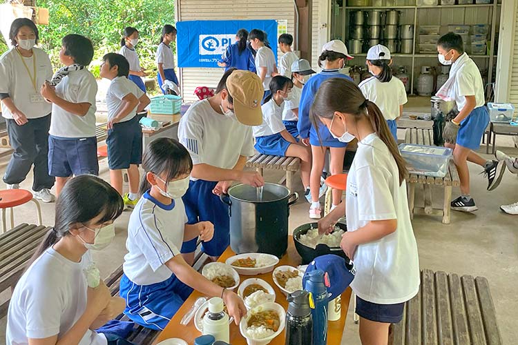 写真：完成したカレーライスを盛り付け（小学校遠足）