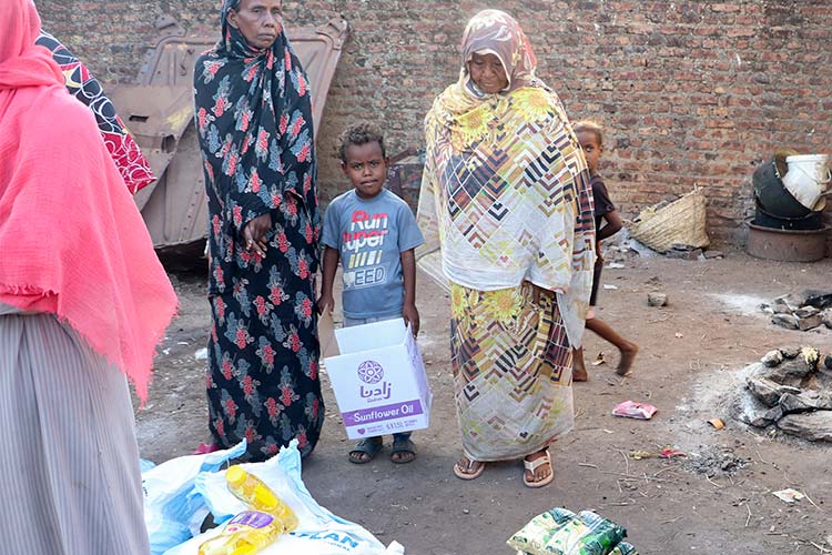 写真：「食料セット」の受け取りを待つ国内避難民キャンプの家族