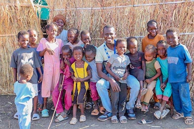 写真：子どもたちとアブバカール職員（中央）