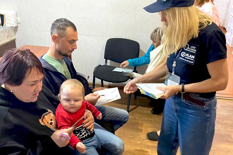 写真：人道支援センターを訪れる人々にリーフレットを配布