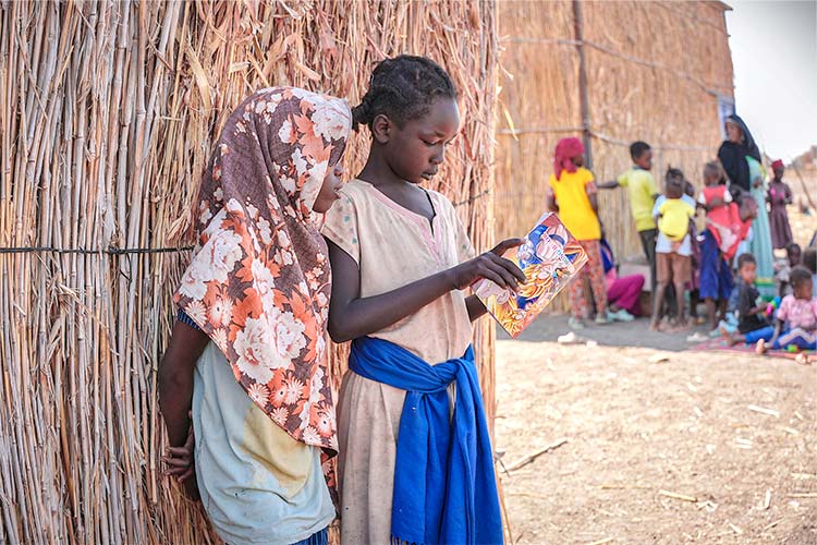 写真：国内避難民キャンプにて　本を読む女の子たち