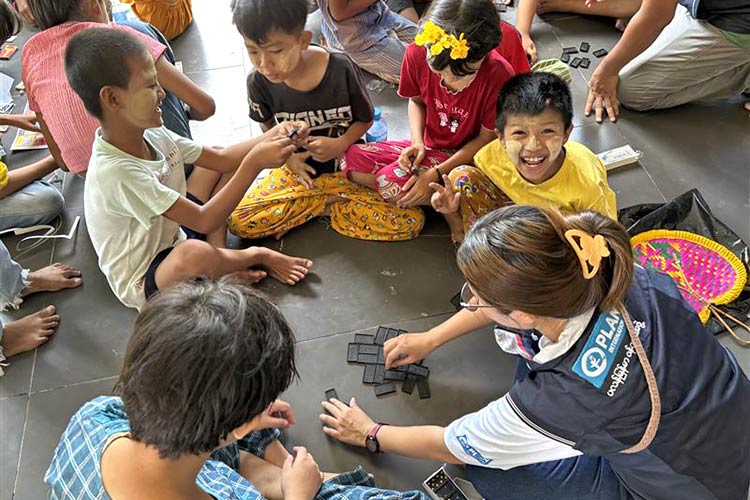 写真：ゲームをして遊ぶ子どもたちとプラン職員