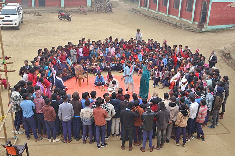 写真:大勢の生徒や教師が集まる子どもクラブの劇