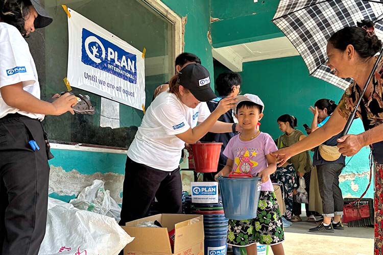 写真：家族と一緒に物資を受け取る女の子