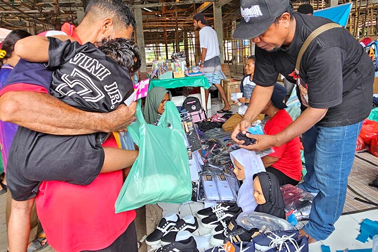 写真:父親と一緒に靴を選びにきた、障害のある男の子