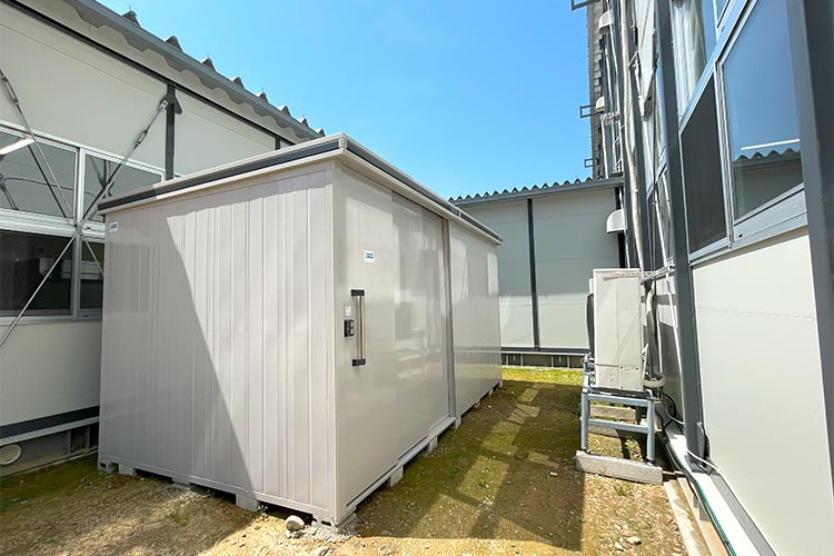 写真：被災した6つの小学校が合同で授業を行う仮設校舎のグラウンドに物置を提供。これから始まる外での体育授業に向けて各小学校から集めた教材を保管