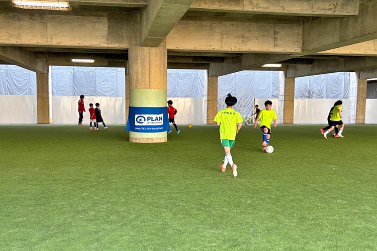 写真：仮設校舎の敷地に整備した運動場。サッカークラブの練習風景