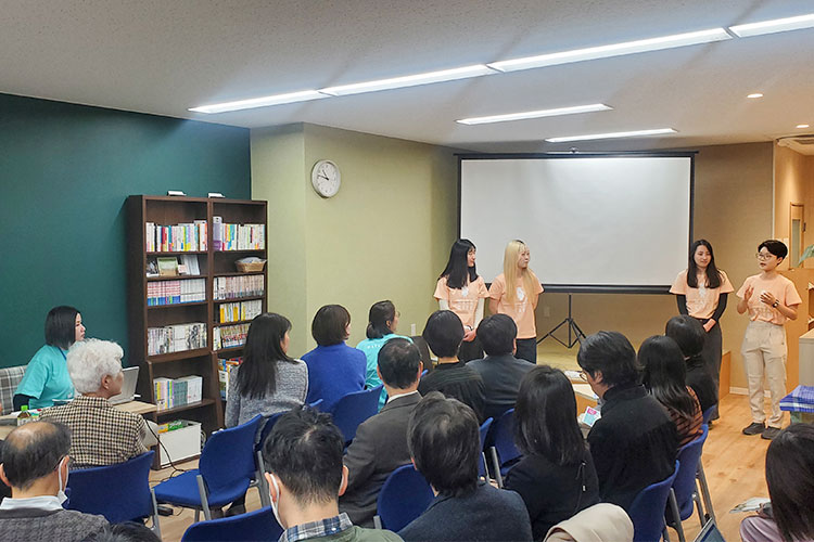 写真：新「わたカフェ」のオープニングセレモニーで発表するプラン・ユースグループ