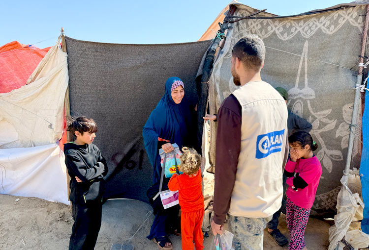 写真:ガザ地区の国内避難民の家族に衛生キットを届けるプラン・インターナショナルの職員