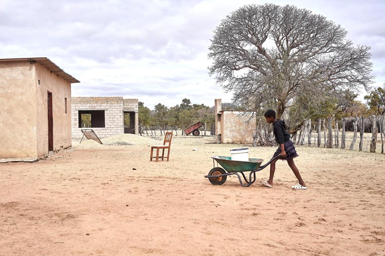 写真:リヤカーで水タンクを運ぶ女の子(ジンバブエ)