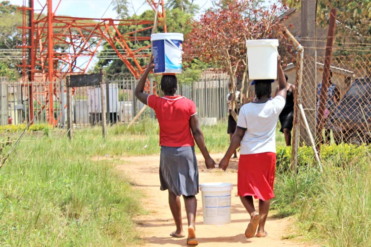 写真:水を運ぶのは女の子や女性の仕事とされている（ジンバブエ）