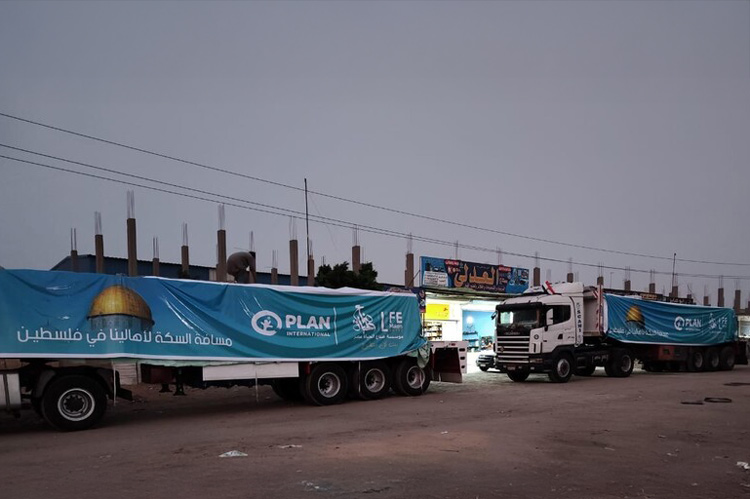 写真:ガザ地区に入るプランのトラック