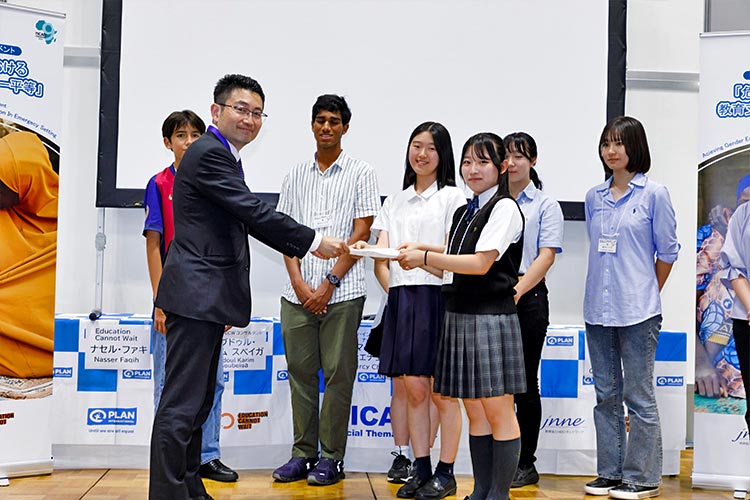 写真：外務省の中村氏（写真左）へ提言書を手渡すユースたち