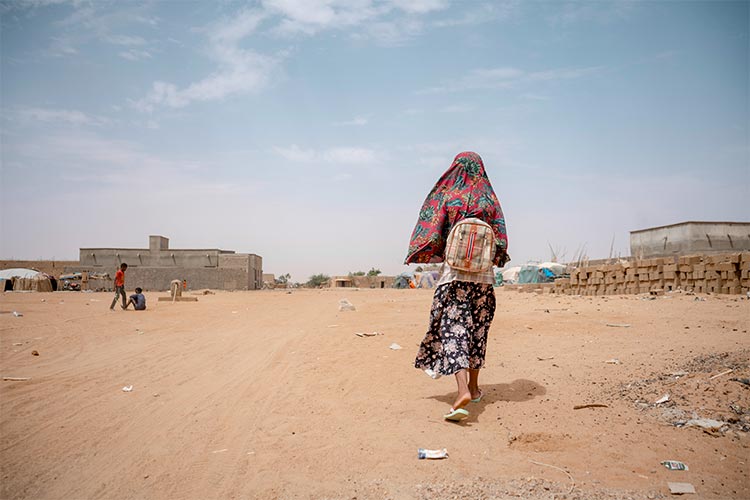 写真:学校から家まで歩く9歳の女の子（マリ）
