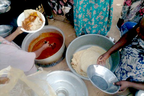 写真：配布した食料を使った避難所での炊き出し。避難民同士で食事を分け合う