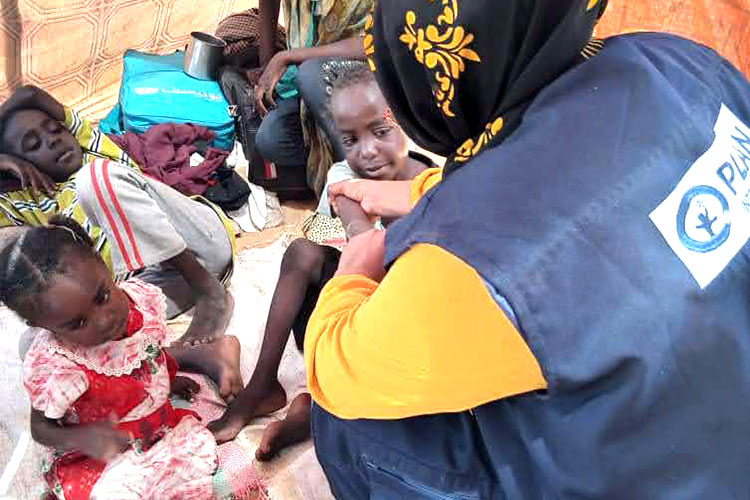 避難民の子どもたちの栄養状態を確認するプラン職員