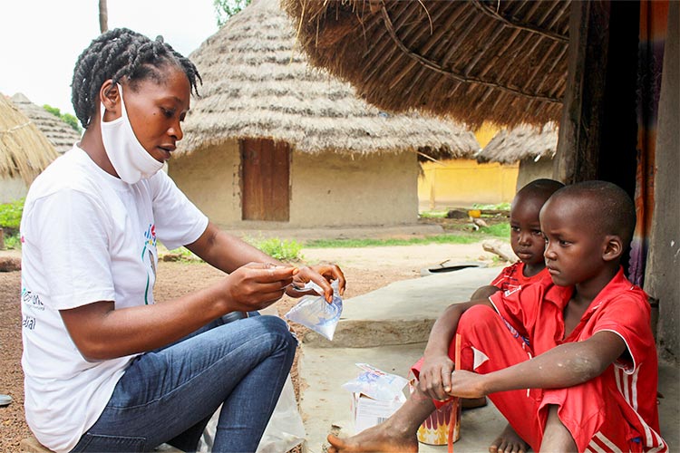 写真:子どもたちに抗マラリア薬を処方するプラン・インターナショナルのスタッフ(ギニア)