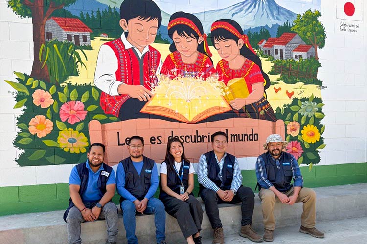 写真：建設された図書館の前で、事業チームメンバーと