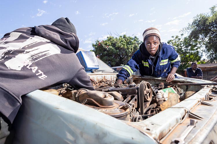 写真：車の整備をするフェアモアさん（右）