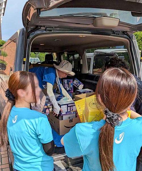 写真：避難所の高校生ボランティアとプラン職員