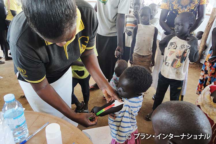 子どもの発育を定期確認する保健ボランティア（ウガンダ）