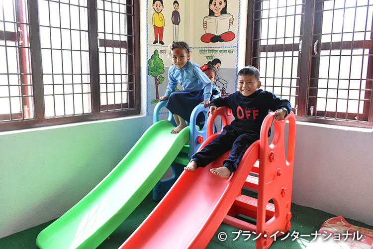 写真：すべり台で遊ぶネパールの子どもたち