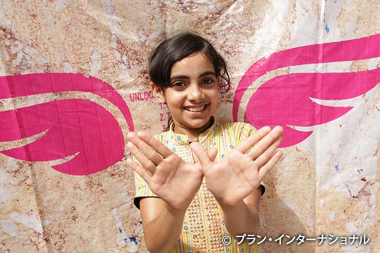 写真：アクションに参加し、羽を手でかたどるパキスタンの女の子