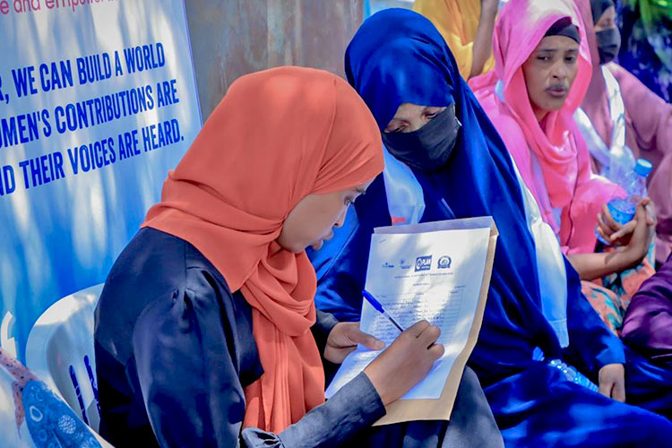 写真:巡回診療の問診票を書く女性