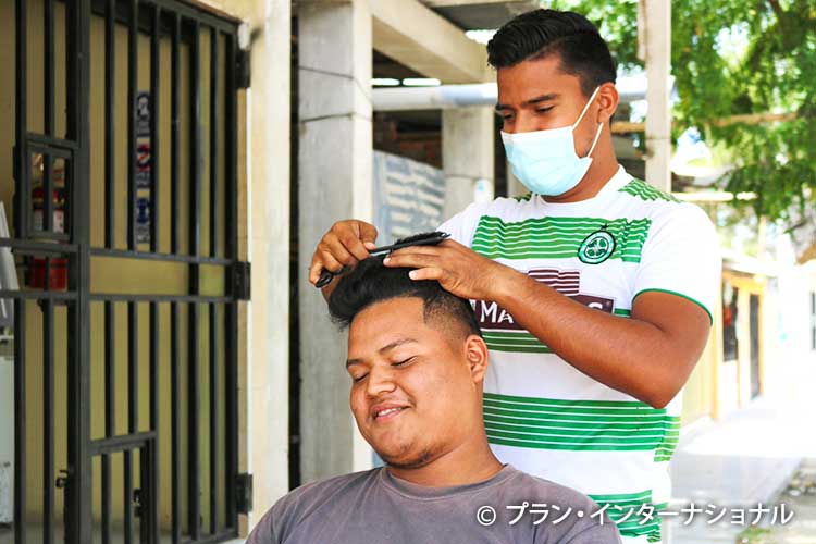 画像：理髪の技術向上に励む若者