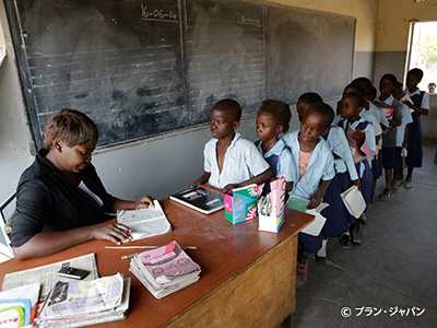 学校で宿題のチェックを受けるチボンボ郡の子どもたち