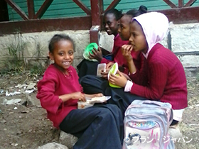 写真：アジスアベバの貧困地区の小学校に通う子どもたち。写真は給食を食べているところ