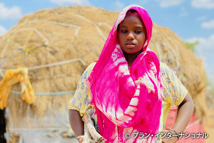 写真:食費を稼ぐために薪を売りにいく13歳の女の子（ケニア）