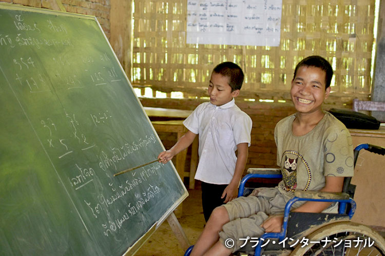 写真：教室で笑顔を見せる車椅子の男の子