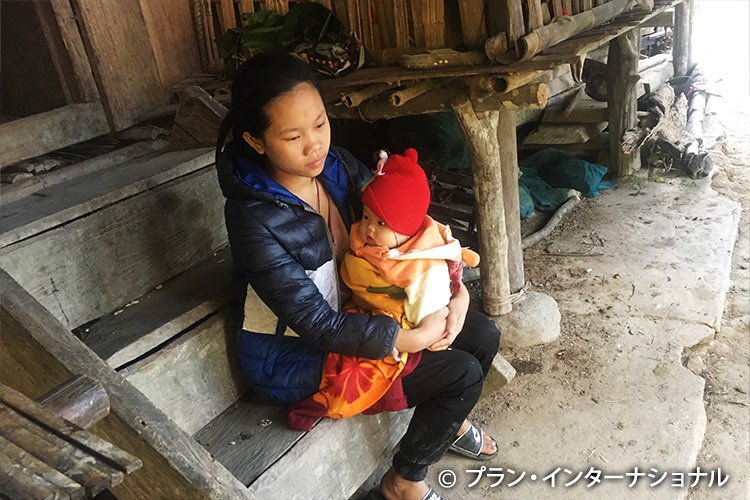写真：赤ちゃんを抱く若い母親（ベトナム）