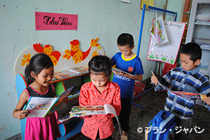 写真：110校に図書を、1・2年生の教室には書棚を支給。絵本を通してベトナム語を学ぶ機会に