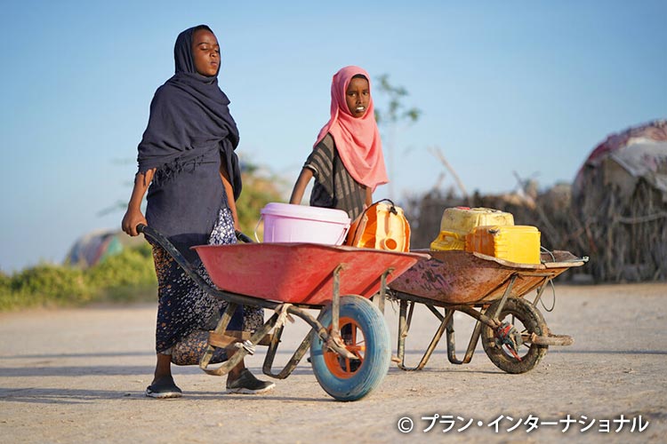写真：手押し車で水を運ぶ女の子たち（ソマリア）