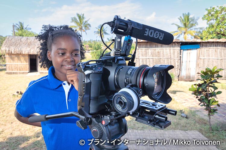 写真：撮影カメラを興味深そうに見ているユーニスさん