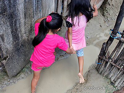 写真不衛生な水溜りを避けて歩く裸足の子どもたち