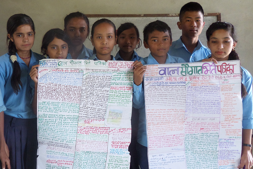 壁新聞を通じて情報発信をする子どもクラブのメンバー / ©プラン・ジャパン