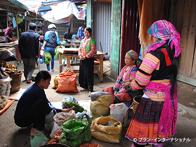 写真：市場で野菜や果物を売るモン族の女性たち
