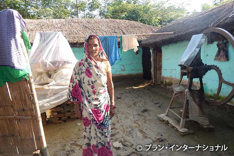 写真：家から家財道具を運びだした女性（インド）