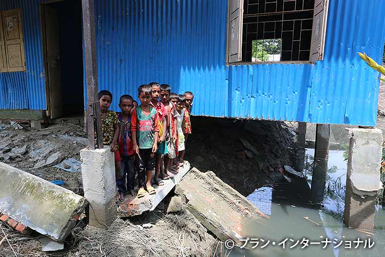 写真：洪水で損壊した学校の前で（バングラデシュ））