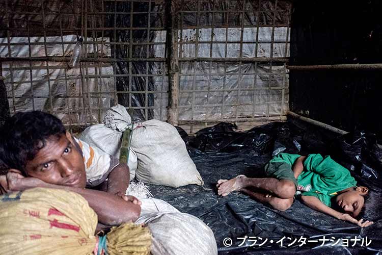 写真：2難民キャンプで休む疲弊した難民の親子